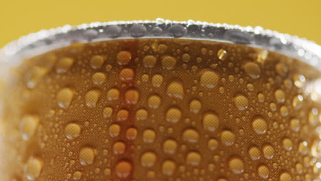 Close-Up-Of-Condensation-Droplets-On-Revolving-Takeaway-Can-Of-Cold-Beer-Or-Soft-Drink-Against-Yellow-Background-1